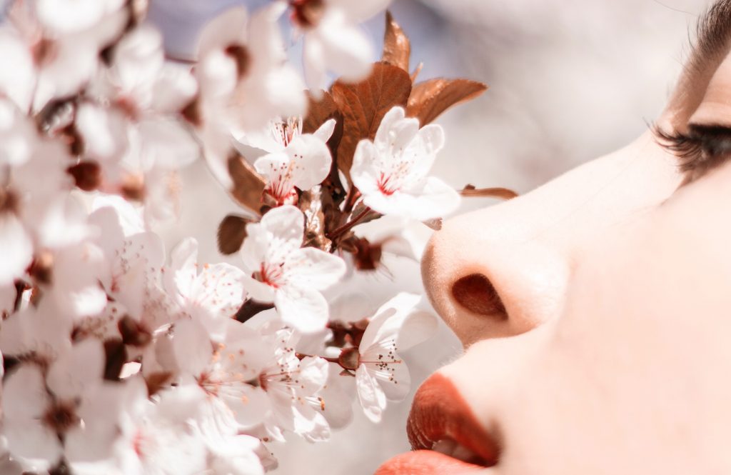 Aromacologia. Una donna annusa fiori profumati