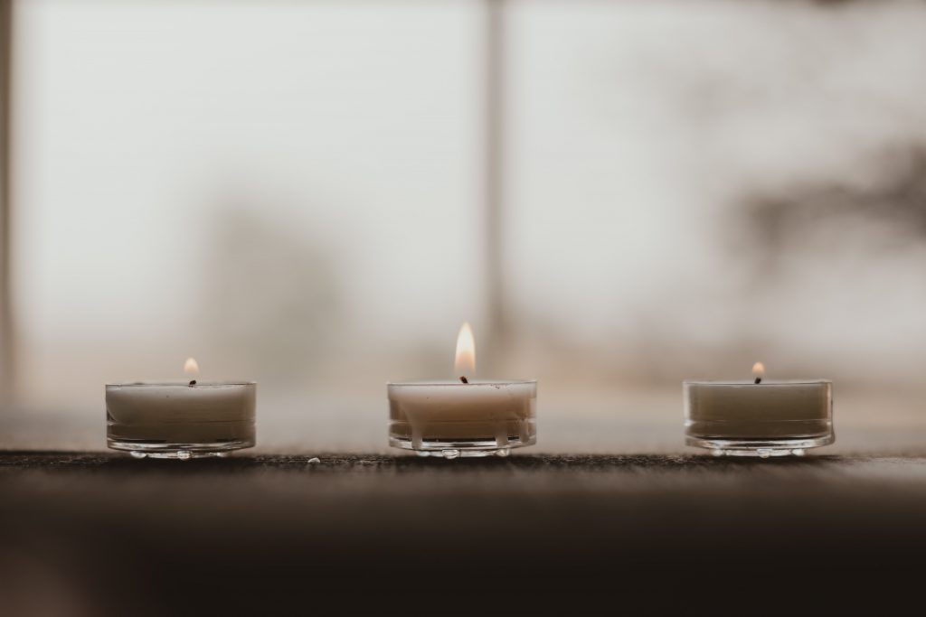 Tre mini candele su un piano di legno